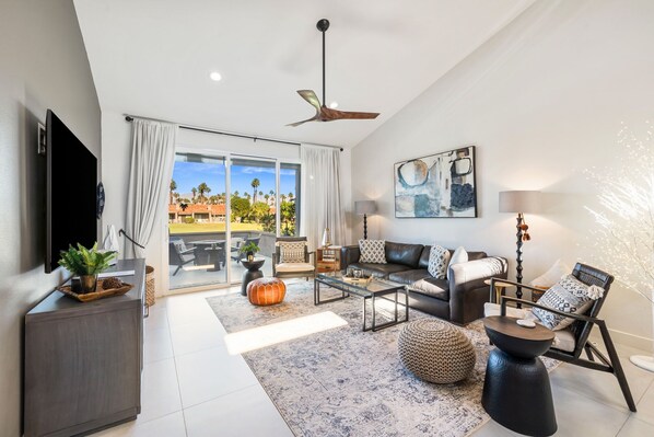 A spacious living room with a sofa, coffee table, and a TV on a cabinet. - Stunning, Fully Remodeled 2-Bed/2-Bath Residence in Serene Palm Desert (Palm Desert)