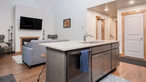 A modern kitchen with a central island, a built-in oven, and a sink. - Peaceful 2-bedroom house in charming Seeley Lake (Seeley Lake)