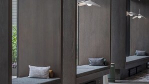 A modern interior with built-in seating areas, pendant lighting, and a large window providing natural light. - Stylish 1BR in Assembly Square | Pool, Gym & Views (Somerville)