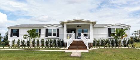 A two-story house with a front porch, a staircase, and a well-maintained lawn.