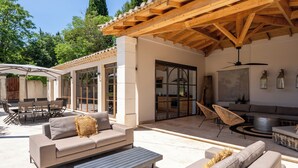 An outdoor patio area with a wooden pergola, a sofa, a dining table, and a grill. - Bastide of the Rose Comtesse – The Art of Intimate Luxury in Provence (Ventabren)