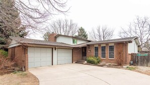 A two-story house with a garage, a front porch, and a small front yard.