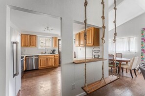 A modern kitchen with wooden cabinets, stainless steel appliances, and a hanging swing. - Walkable Longmont board games, beds, and boats - 4BR (Longmont)