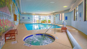 Ein Hallenbad mit Whirlpool, Bänken und einem Wandgemälde.