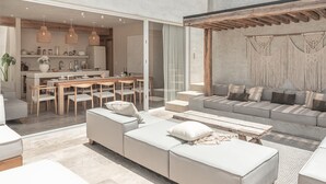 En moderne stue med sofa, sofabord og spiseplads.