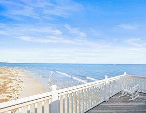 A wooden deck with white railings overlooking a beach. - Marvelous 4-bedroom Oceanfront home in Harbor Island (Harbor Island)