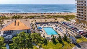 A resort with a swimming pool, beach access, and a parking area.