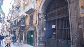 A narrow street with historic buildings, a green door, and a barred gate. - San Liborio bed and breakfast (Naples)