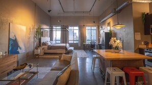 Un apartamento moderno con una cama grande, comedor y cocina.