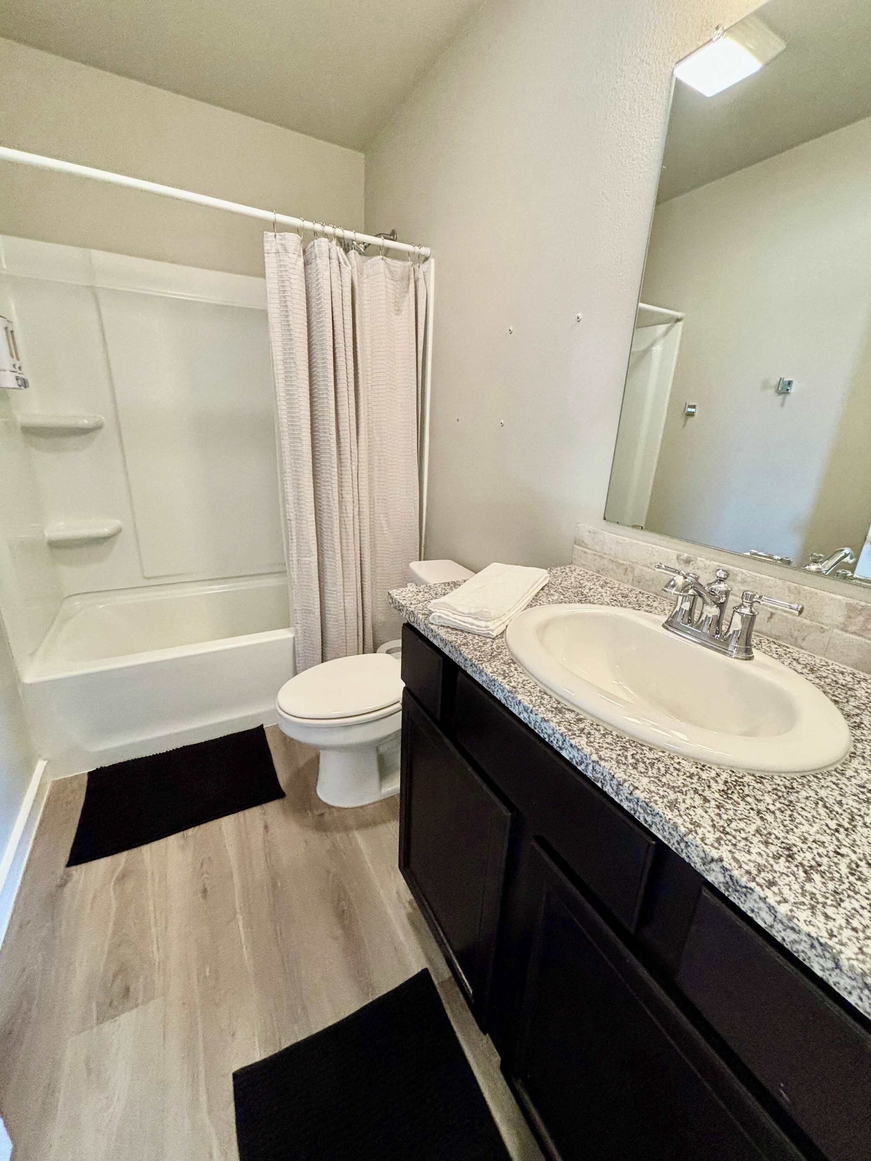 A bathroom with a bathtub, toilet, and sink.