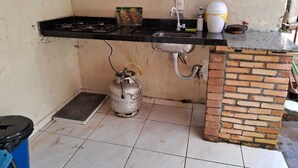 Cuina petita amb fogó de gas, rentapelats i garrafa de gas.
