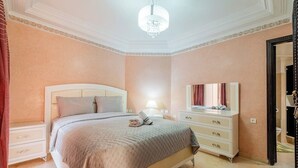 A bedroom with a bed, bedside table, dresser, and a mirror. - Luxe Appt 2 CH Piscine & Parking (Marrakech)