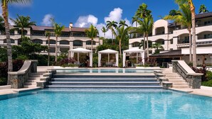 A hotel with a large pool, multiple levels, and outdoor seating areas. - Newly renovated luxurious 2 bedroom 2 1/2 bath beachfront condo. (St Thomas)