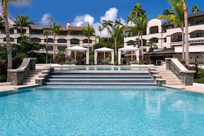 A hotel with a large pool, multiple levels, and outdoor seating areas. - Newly renovated luxurious 2 bedroom 2 1/2 bath beachfront condo. (St Thomas)