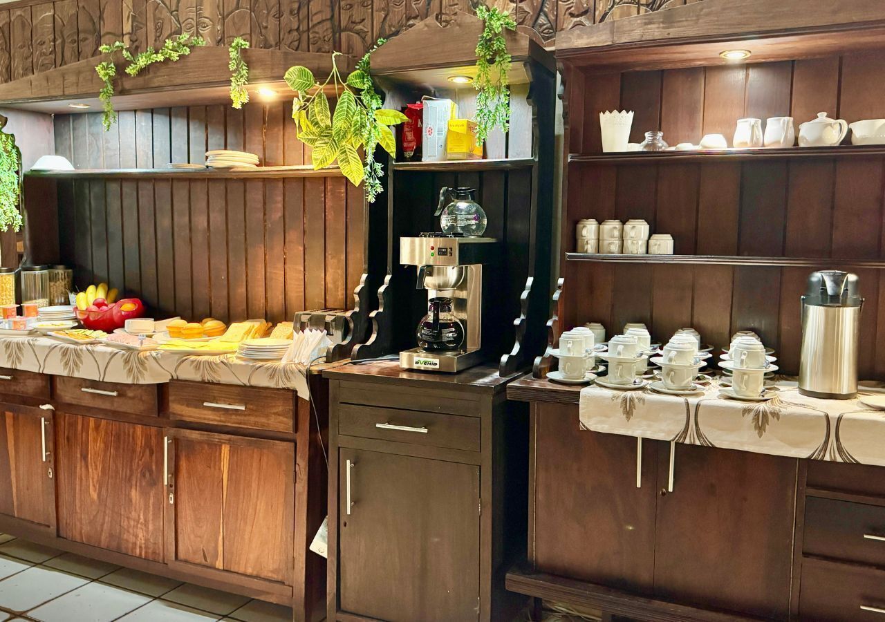 A kitchen area with a coffee machine, fruit, and various kitchenware.