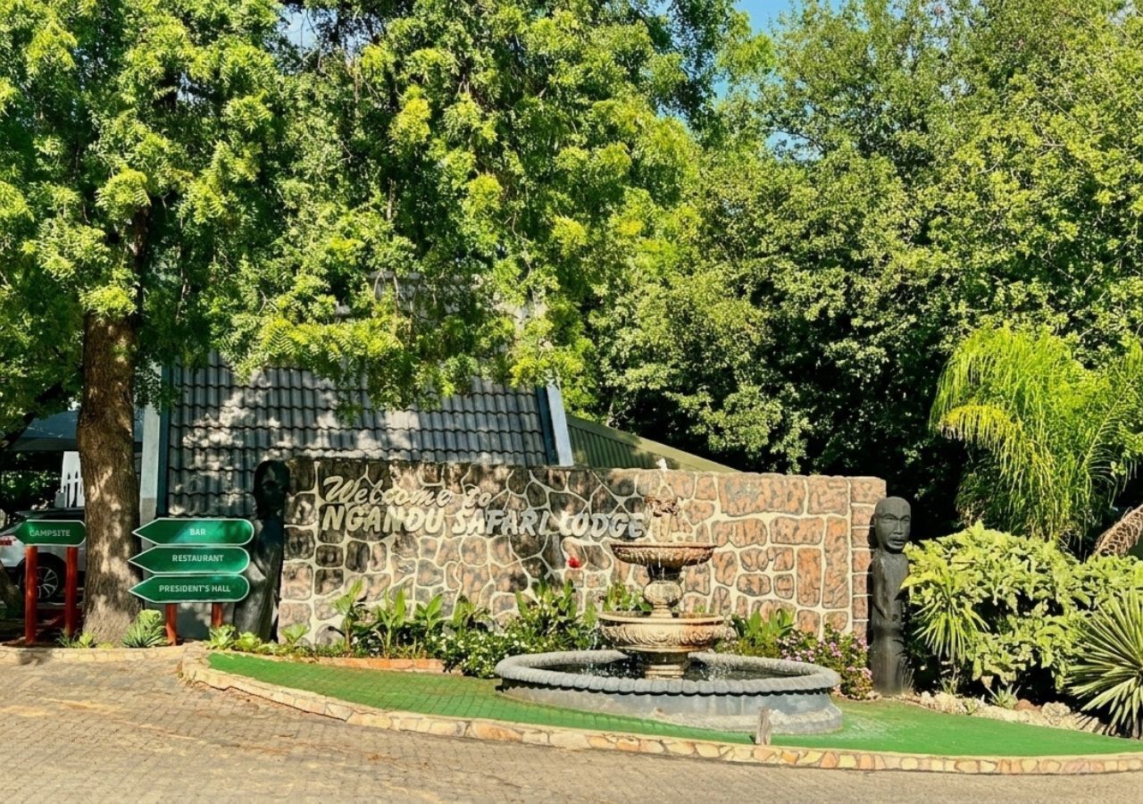 A stone wall with a sign reading 'Welcome to Ngandu Safari Lodge' and a fountain in the foreground.