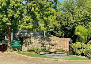 A stone wall with a sign reading 'Welcome to Ngandu Safari Lodge' and a fountain in the foreground. - Ngandu Hotel - Rundu (Rundu)