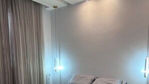 Une chambre à coucher moderne avec un lit, des oreillers et une couverture.