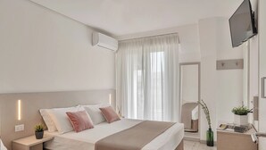 A hotel room with a bed, bedside tables, a TV, a mirror, and a window with curtains. - Hotel Lux (Gabicce Mare)