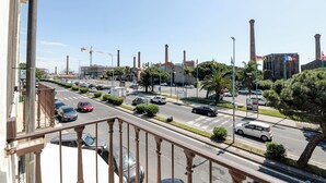 Vista da rua com carros, um canteiro de obras e edifícios ao fundo.