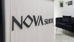 Placa com a inscrição 'NOVA SUITE' em uma parede clara.