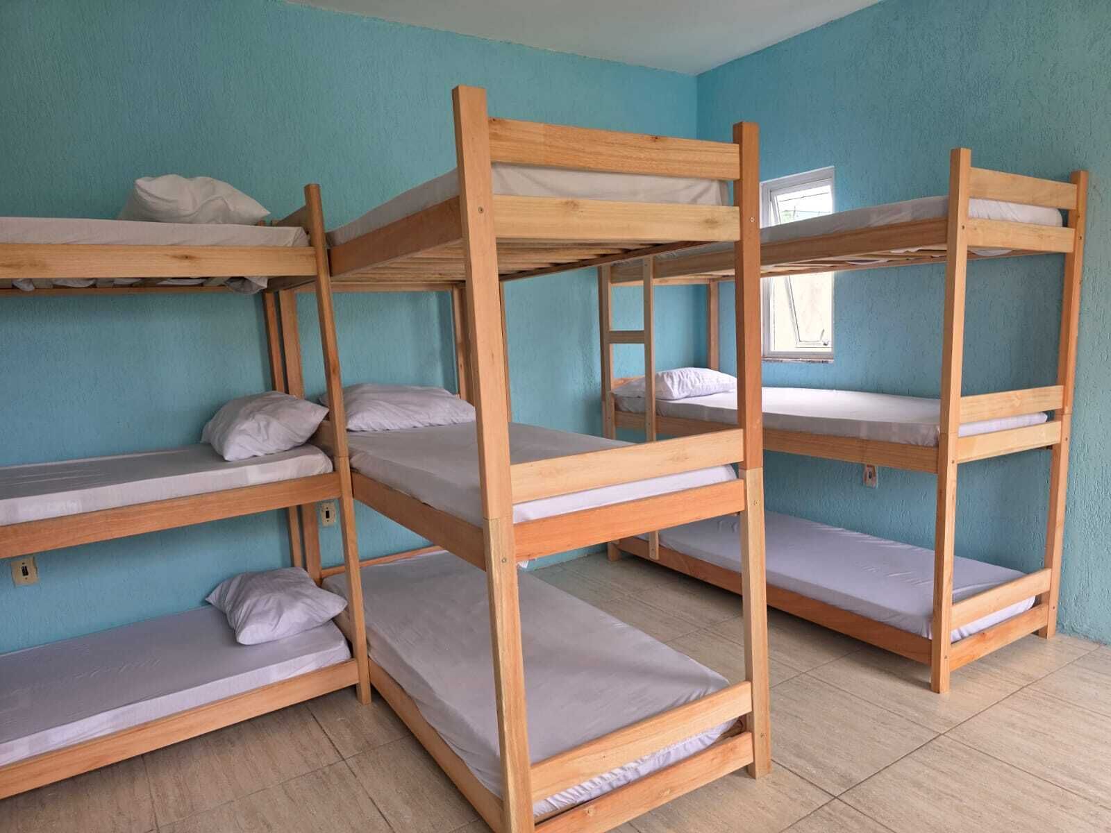 A room with bunk beds, a window, and a tiled floor.