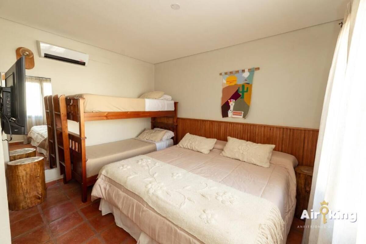 Una habitación con literas, un televisor y un cartel en la pared.