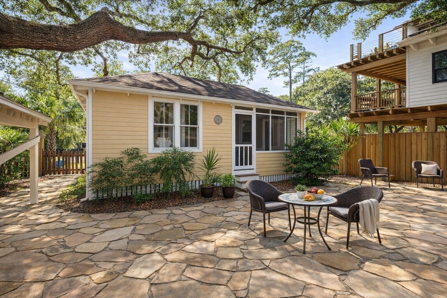 A house with a stone patio, outdoor seating, and a covered porch.