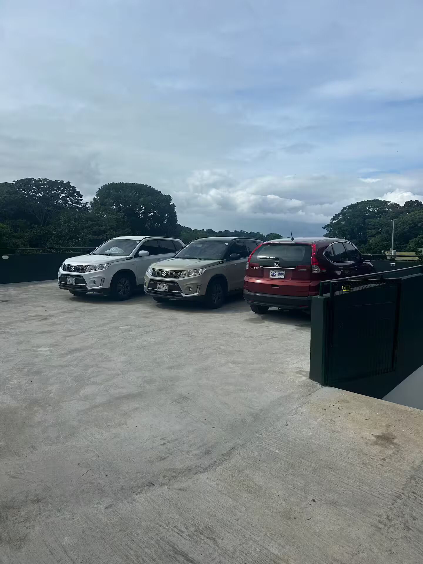 Un parking où sont garées trois voitures.
