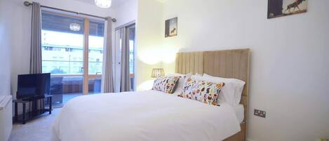 2 dormitorios y tabla de planchar con plancha