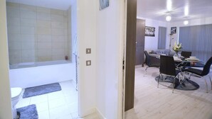 En moderne stue med spiseplads, sofa og sofabord.