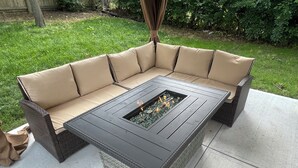 A sectional sofa with a built-in fire pit table. - Comfort & Space: 5BR Family Getaway w/ Pool, Fire Table, and game room! (Omaha)