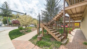 Un bâtiment doté d’un escalier menant à une entrée abritée, d’un trottoir et d’un petit espace jardin.