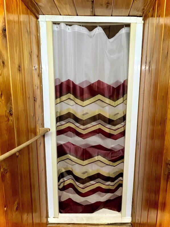 A shower curtain with a chevron pattern. - The Wolf Waystation — Rustic Cabin with Sauna (Delta Junction)