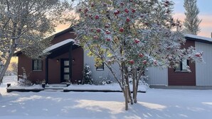 Une maison à deux étages avec un porche à l’avant et un garage.
