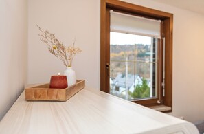 A room with a wooden table, a white vase with dried flowers, and a lit candle. - Completely renovated vacation home in the beautiful Ore Mountains in a quiet location (Breitenbrunn/Erzgebirge)
