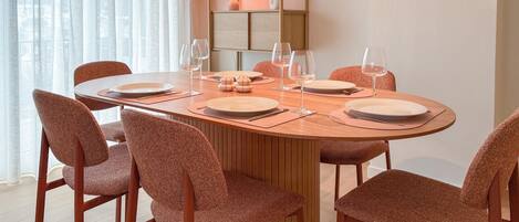 Un comedor con una mesa redonda dispuesta para cuatro personas, rodeada de sillas a juego.