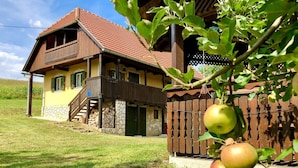 A two-story house with a red-tiled roof, a balcony, and a wooden fence. - 1 bedroom cozy home in Duga Resa (Duga Resa)