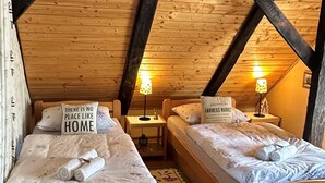 A cozy attic bedroom with two wooden beds, each with a pillow stating "There is no place like home." - 1 bedroom cozy home in Duga Resa (Duga Resa)