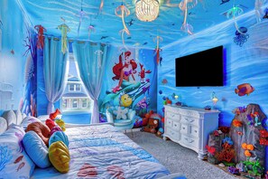 Une chambre à coucher avec un lit, une commode et une grande fenêtre.