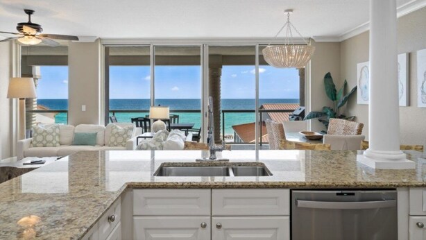 A kitchen with a view of the ocean, a dining area with a table and chairs, and a large window. - NEW!!  BEACHFRONT 3-bedroom condo in Pensacola.  Walk to restaurants and shops! (Pensacola)