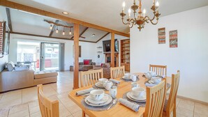 A dining area with a wooden table set for four, surrounded by wooden chairs. A chandelier hangs above the table. - 'The Chillville in Cornville' - Saltwater Pool! (Cornville)