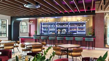 A modern bar area with multiple seating options and a well-stocked liquor display.