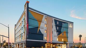 Ein modernes Hotel mit einer geometrischen Fassade, mehreren Etagen und einem markanten Eingang.