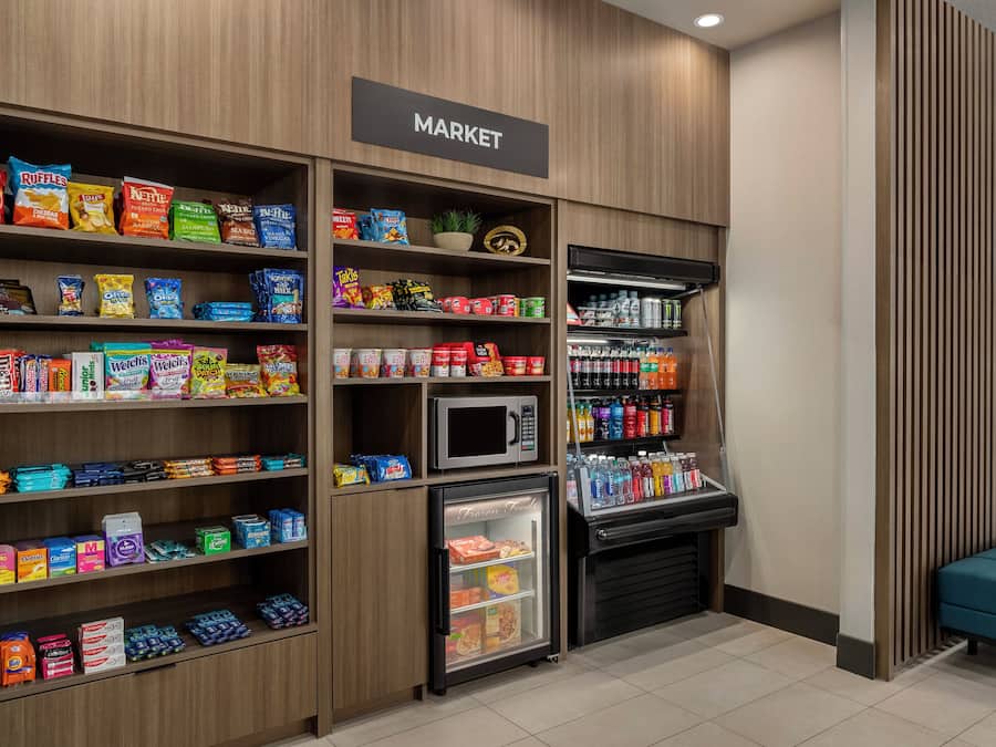 Zona autoservicio con estantes llenos de refrigerios, bebidas y alimentos congelados.