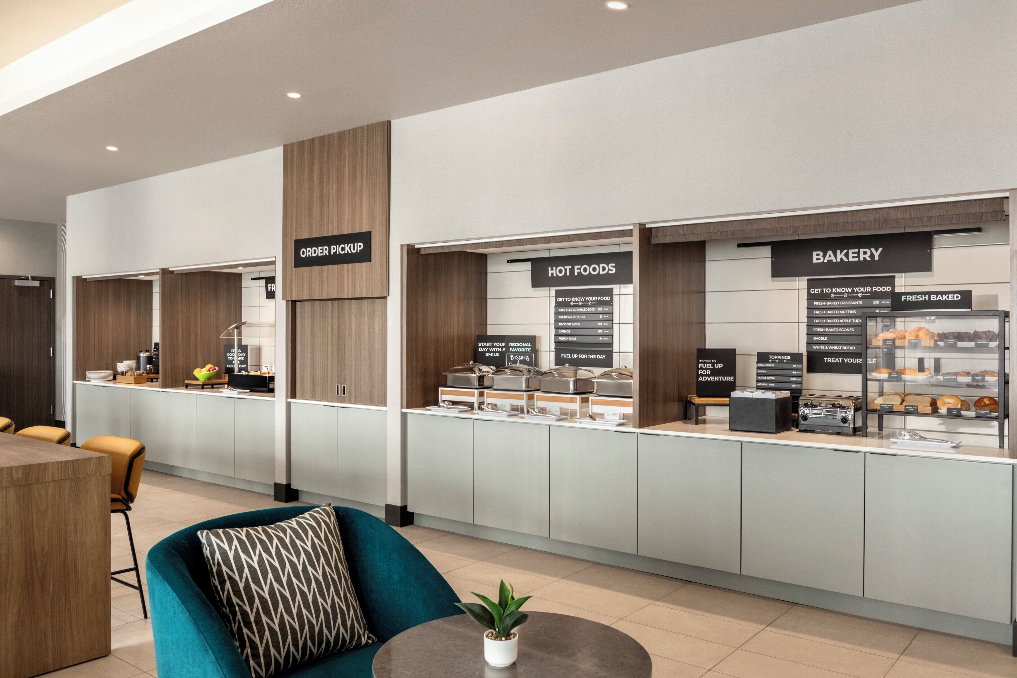 Eine moderne Hotelhalle mit Bäckerei und einem Bereich für warme Speisen.