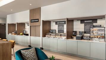 Eine moderne Hotelhalle mit Bäckerei und einem Bereich für warme Speisen.