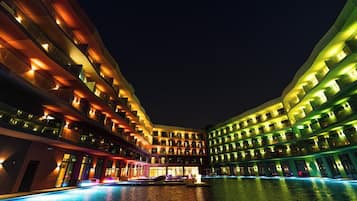 Una piscina al aire libre, sombrillas, sillones reclinables de piscina