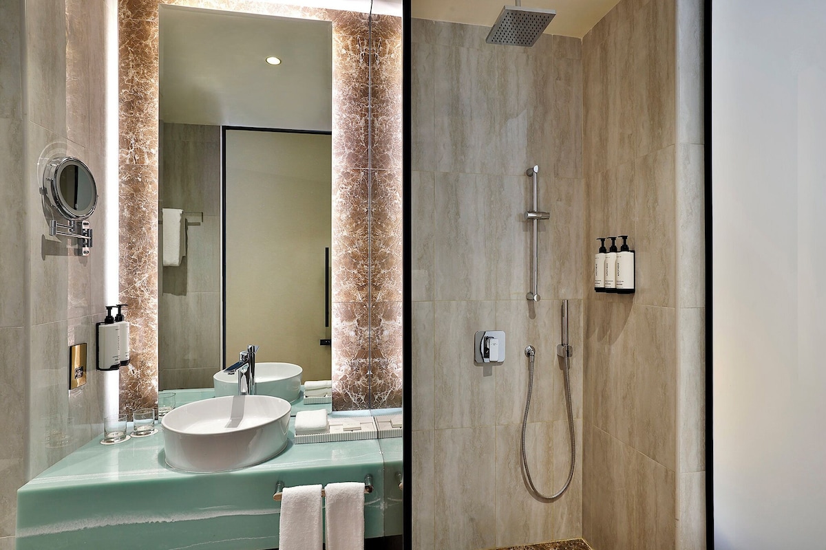 Ein Badezimmer mit Waschbecken, Spiegel und Dusche.