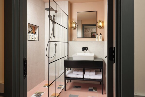 A bathroom with a glass shower enclosure, a white sink, and a black vanity. - Hotel Indigo Gloucester The Forum By IHG (Gloucester)